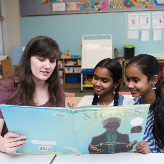 Woman reading to two young girls