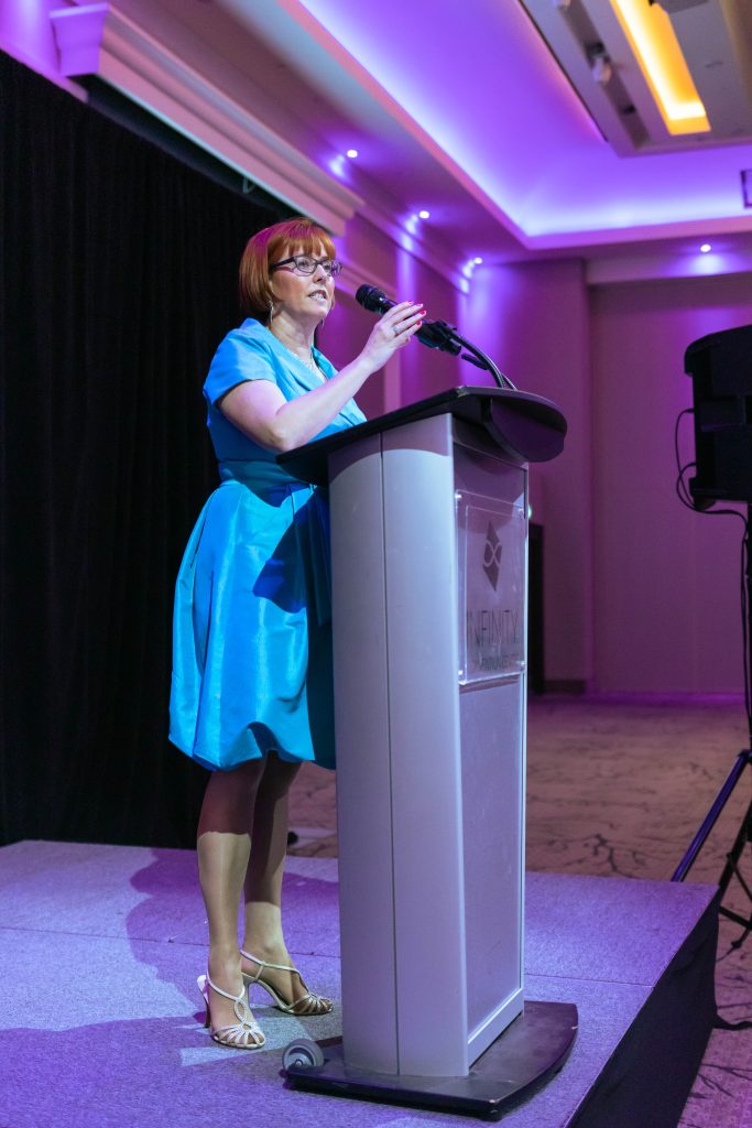 Heather Norris holding microphone speaking